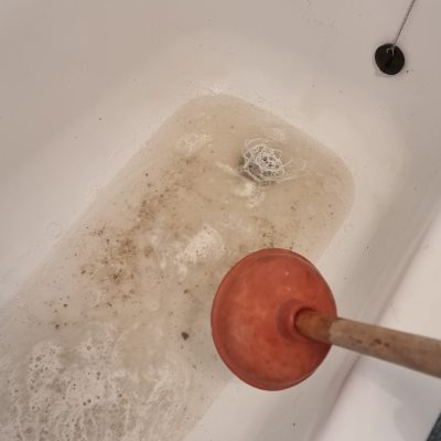 Emergency plumber clearing blocked drain in Bletchley