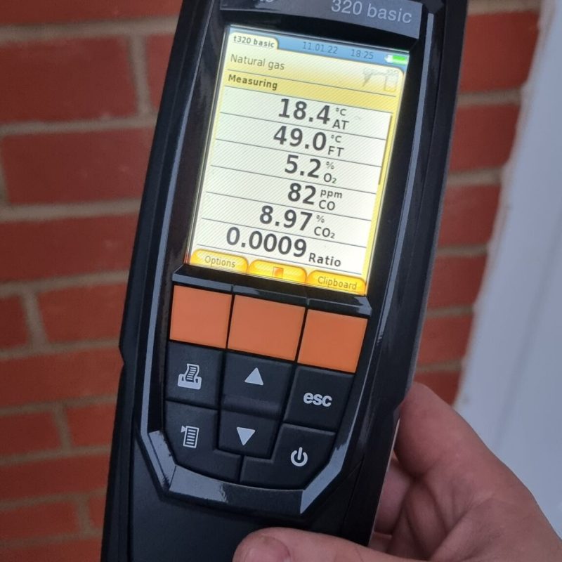 Emergency plumber using gas analyser during boiler repair in Bletchley