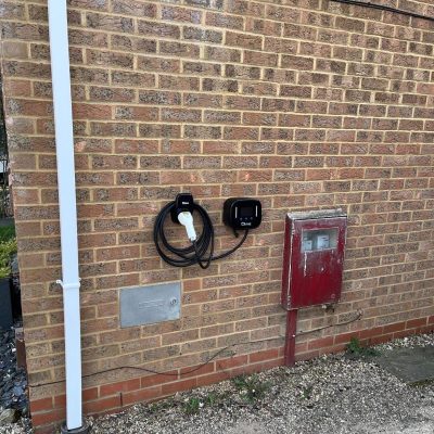 Electrician fitting a home electric vehicle charging point. Emergency electrician installing EV charger in Milton Keynes