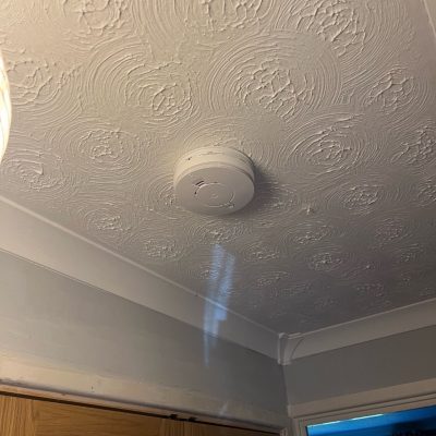 Electrician installing and testing fire safety equipment. Emergency electrician testing smoke alarms in Milton Keynes