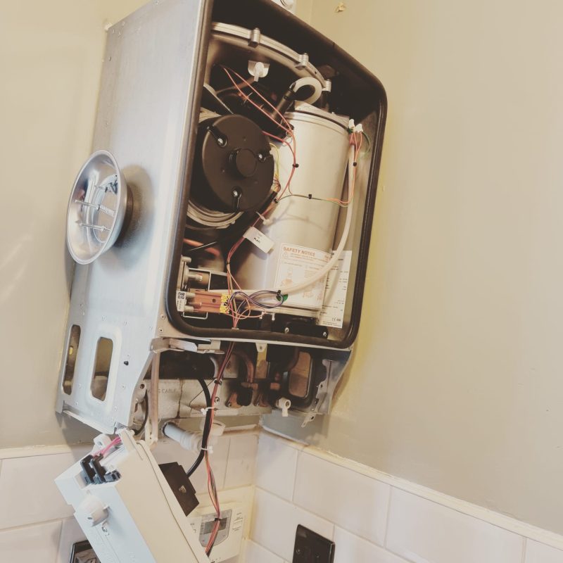 A professional plumber doing gas boiler maintenance