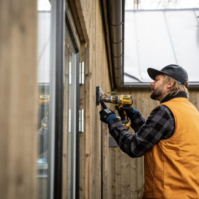 Electrician in high-vis repairing a consumer unit during an emergency call-out. Emergency electrician repairing outdoor security light Milton Keynes